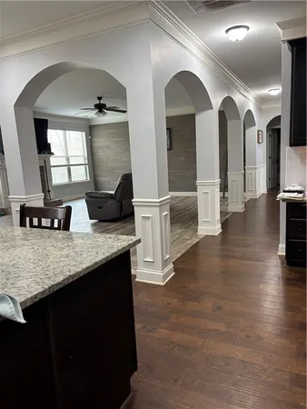 a living room with stainless steel appliances furniture and a wooden floor