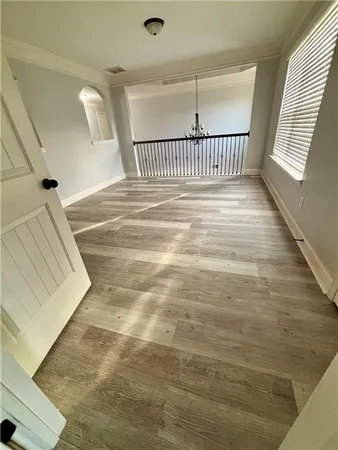 a view of a hallway with wooden floor and stairs