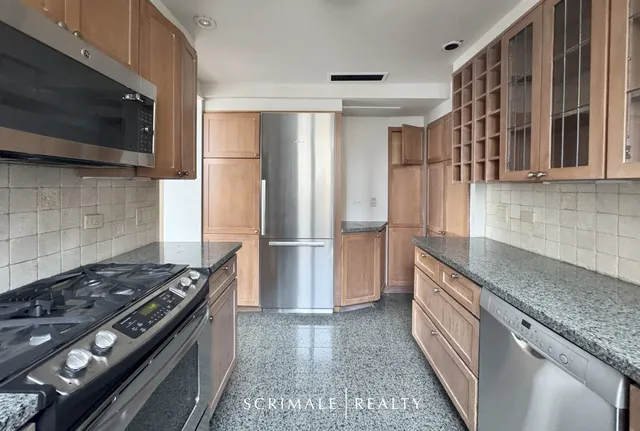 a kitchen with stainless steel appliances granite countertop a sink and a refrigerator