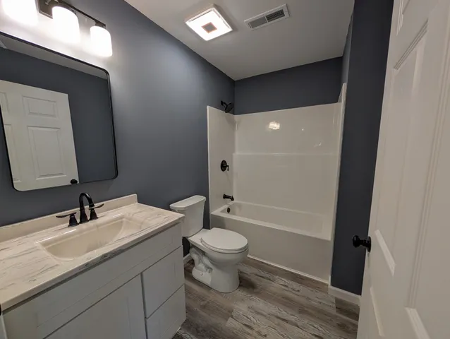 a bathroom with a double vanity sink toilet and shower