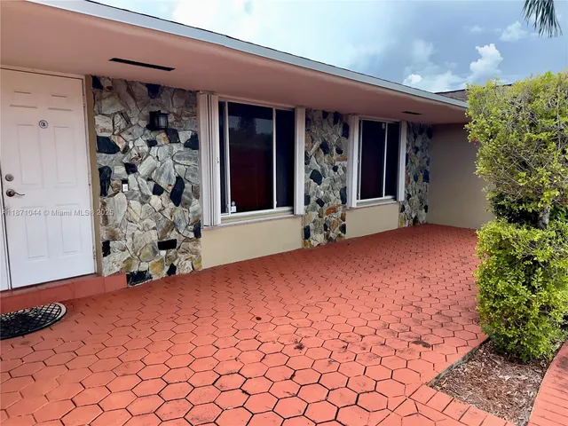 a view of a backyard with couches plants and palm trees