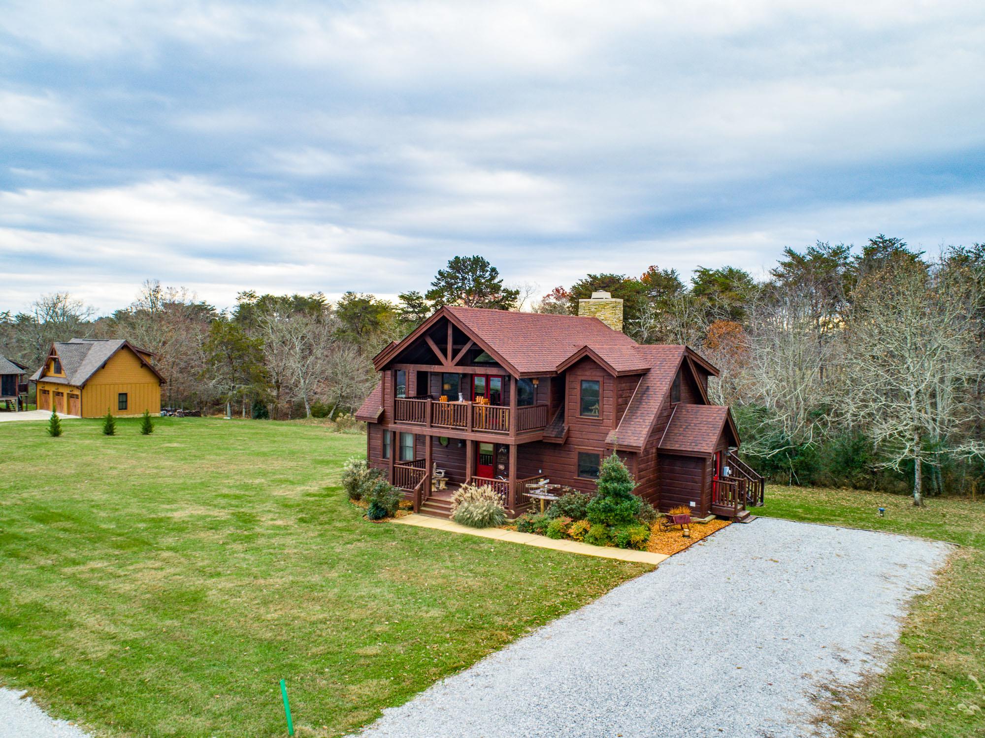 a view of a big house with a big yard and large trees