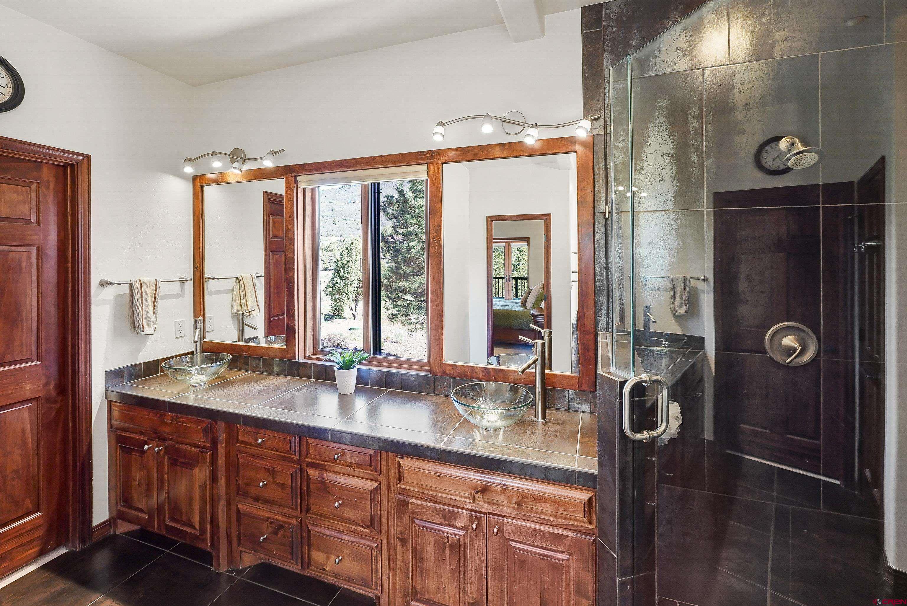 287 Wildcat Road Hesperus, CO 81326 - Photo 18 of 44 a bathroom with a granite countertop sink a mirror and shower