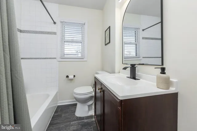 a bathroom with a sink toilet and window