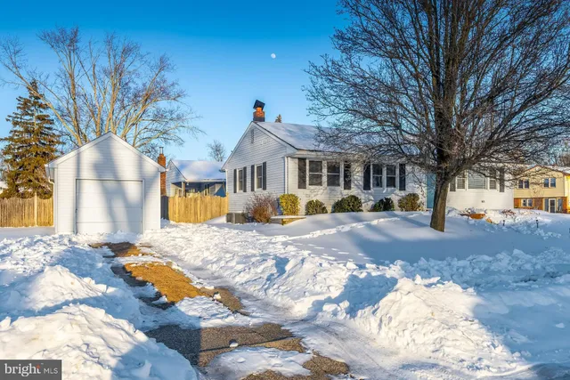 a view of a white house with a yard covered in snow