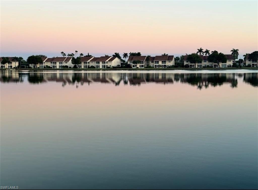 7791 Esmeralda Way, Unit L203 Naples, FL 34109 - Photo 17 of 23 a view of a lake with houses in the back