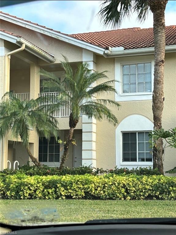 7791 Esmeralda Way, Unit L203 Naples, FL 34109 - Photo 18 of 23 front view of a house with a garden