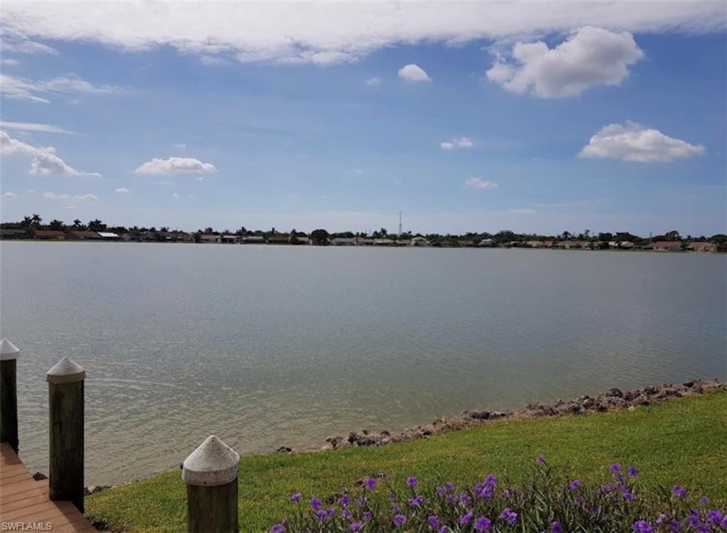 7791 Esmeralda Way, Unit L203 Naples, FL 34109 - Photo 19 of 23 a view of a lake with a house in the background