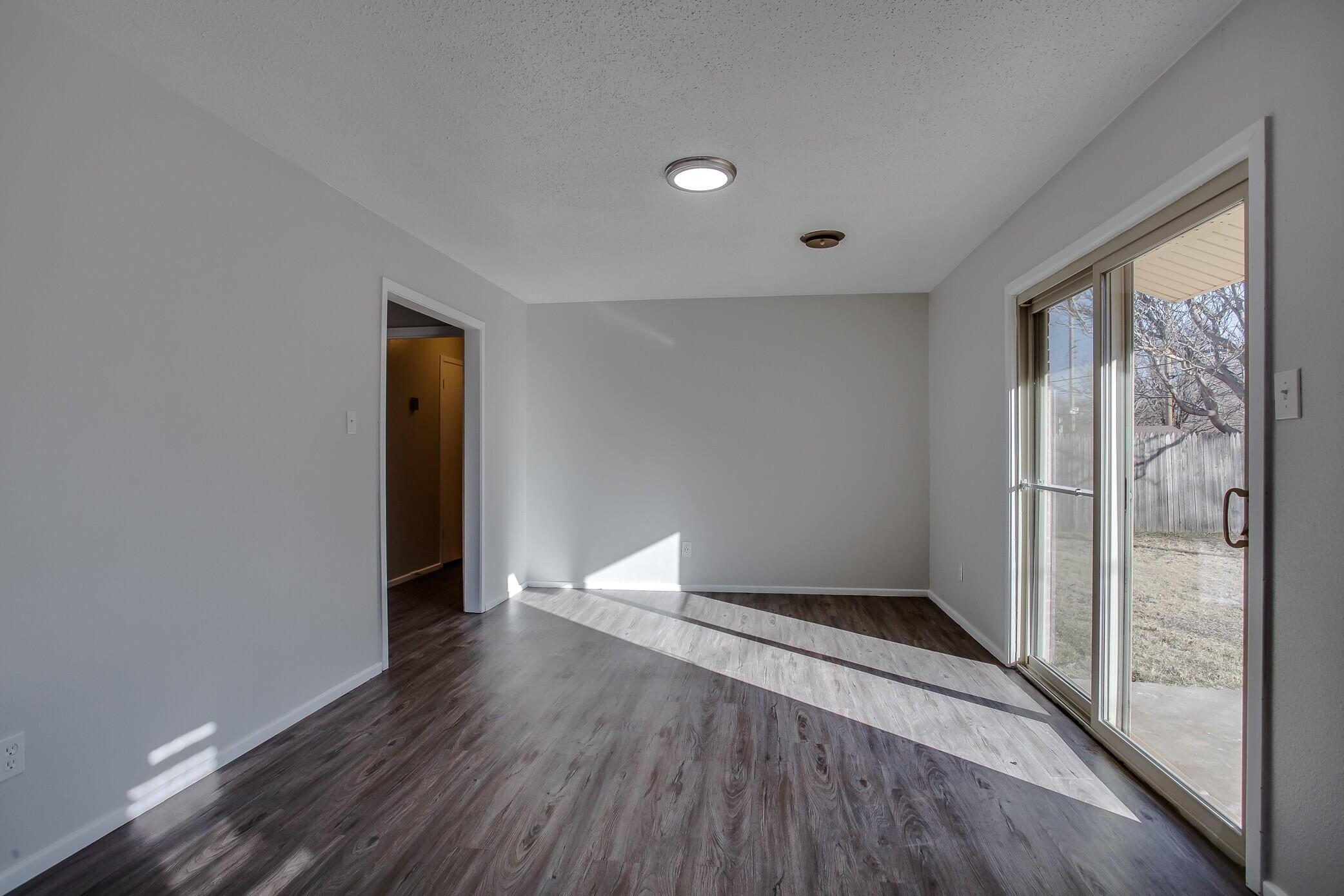 5419 46th Street Lubbock, TX 79414 - Photo 8 of 14 a view of an empty room with wooden floor and a window
