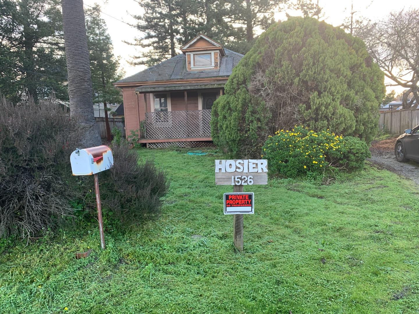a front view of a house with a yard and a street sign
