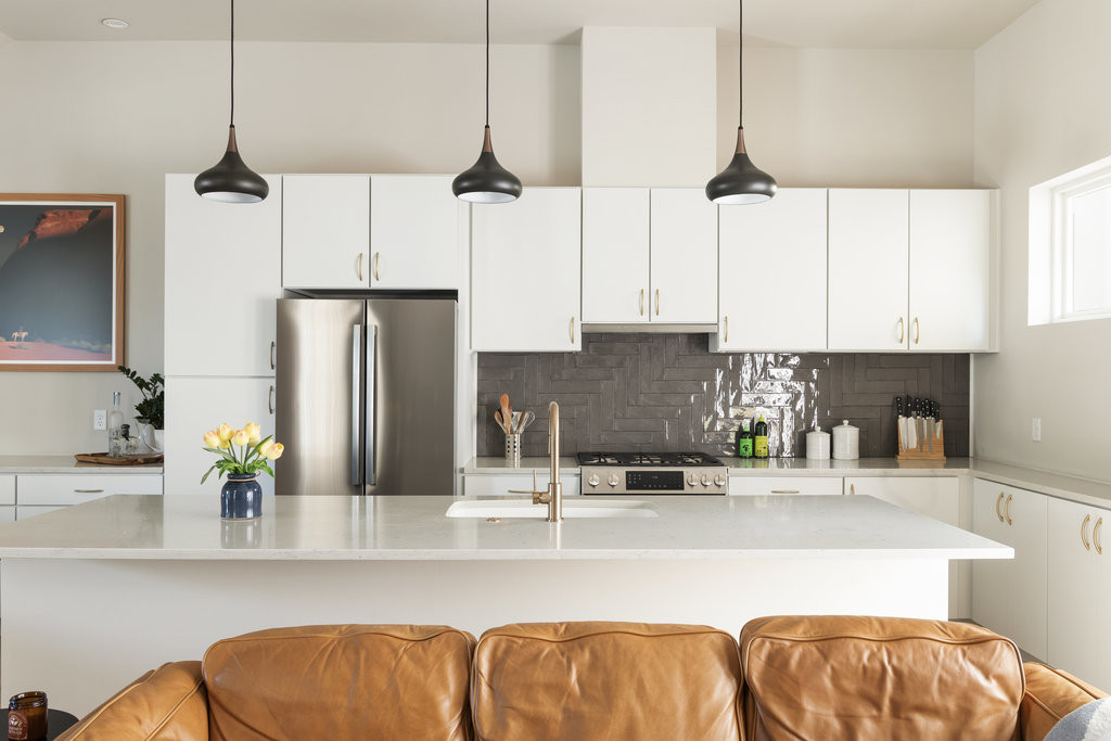2300 Enfield Road, Unit 303 Austin, TX 78703 - Photo 14 of 38 a kitchen with stainless steel appliances kitchen island granite countertop a refrigerator a sink and white cabinets next to a window