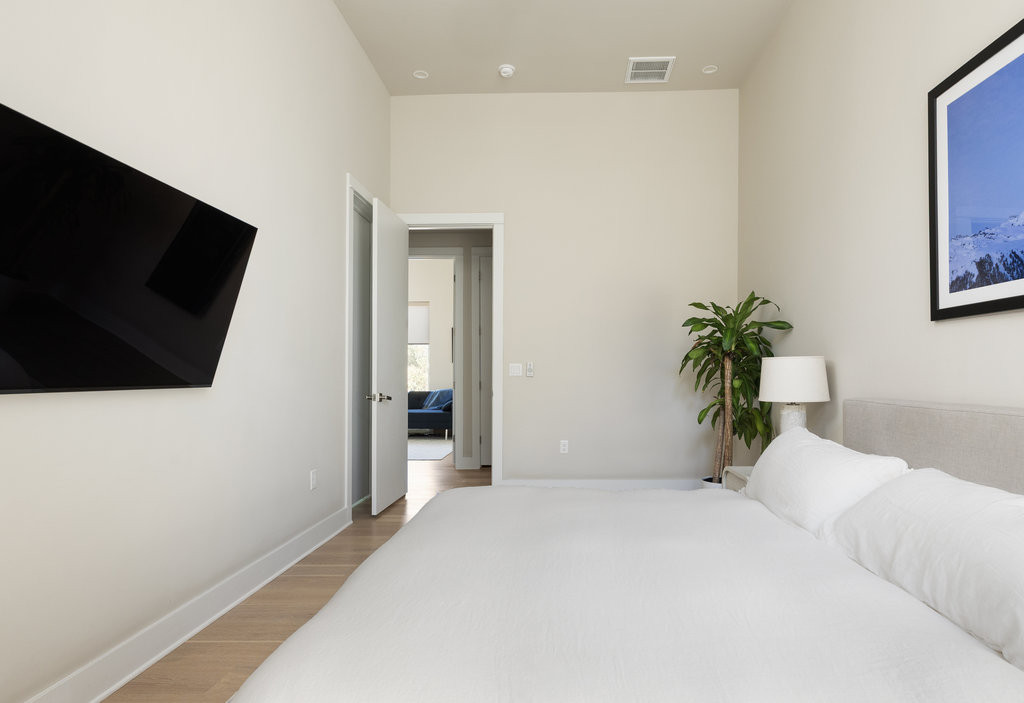 2300 Enfield Road, Unit 303 Austin, TX 78703 - Photo 25 of 38 a bedroom with a bed and a flat screen tv