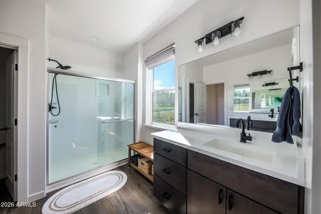 a bathroom with a double vanity sink toilet mirror and shower