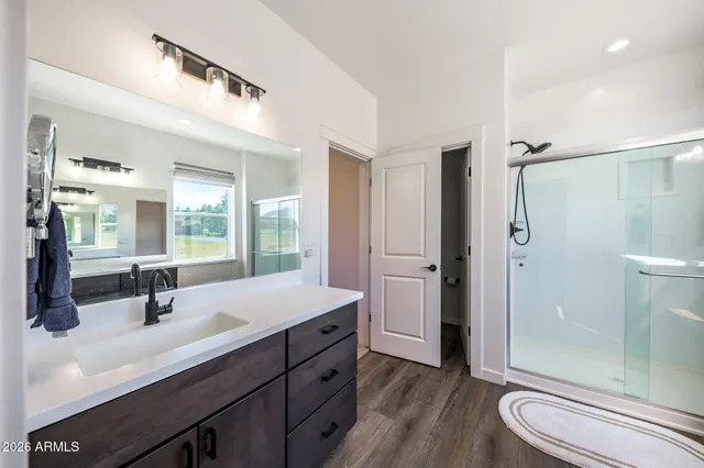 a bathroom with a double vanity sink toilet mirror and windows