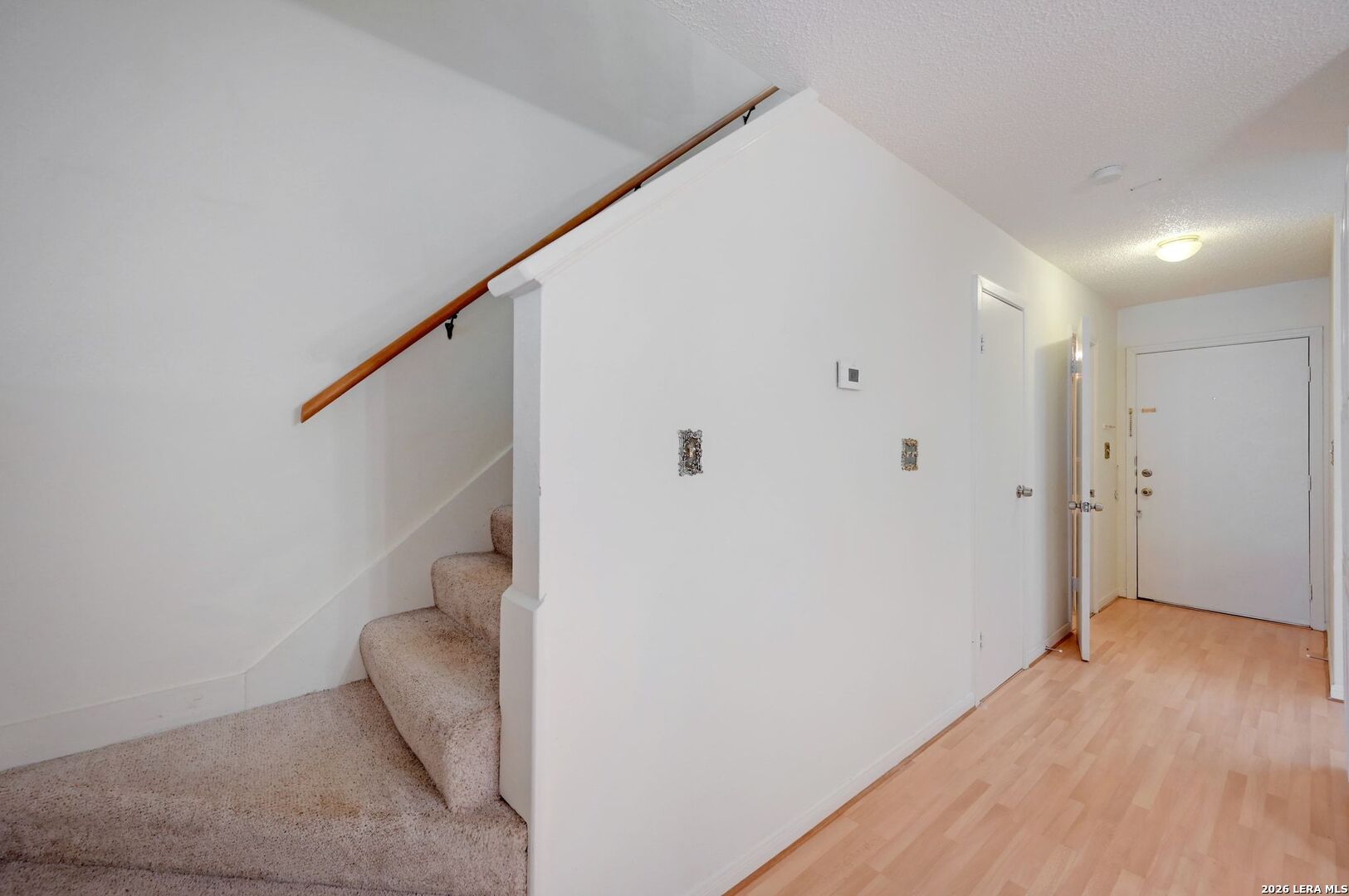 11815 Vance Jackson Road, Unit 1402 San Antonio, TX 78230 - Photo 15 of 29 a view of a hallway with wooden floor and staircase