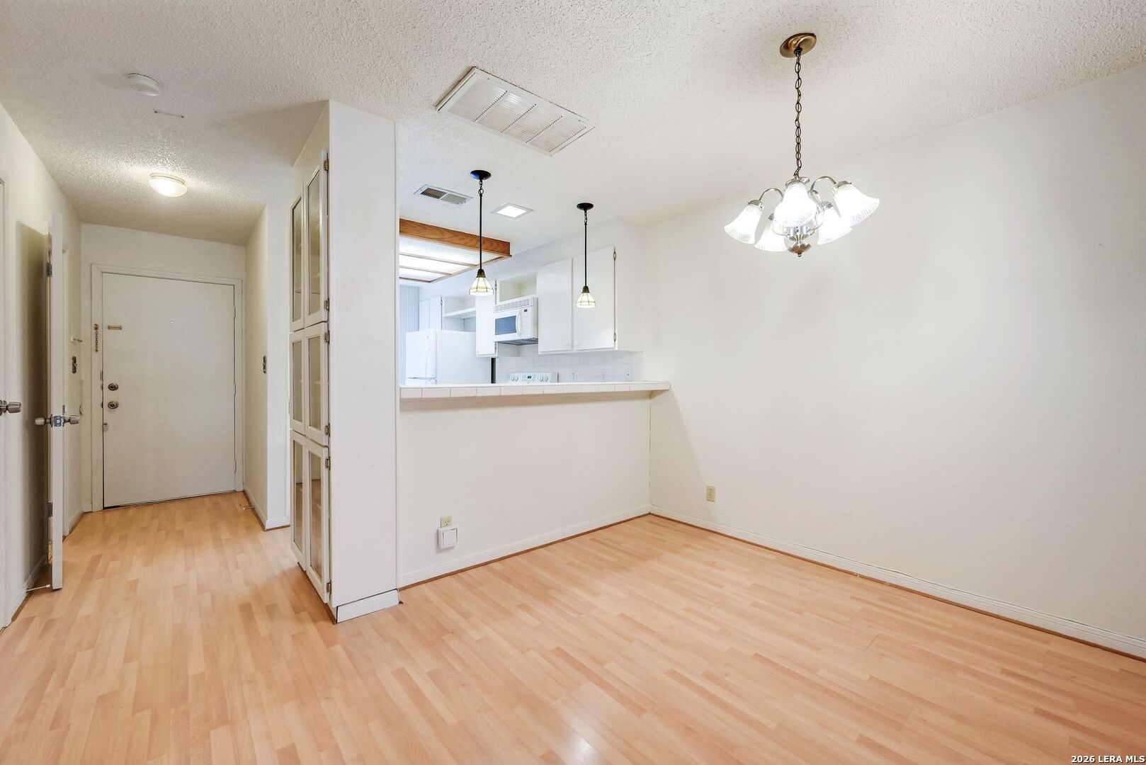 11815 Vance Jackson Road, Unit 1402 San Antonio, TX 78230 - Photo 6 of 29 a view of a kitchen with wooden floor fridge and a ceiling fan