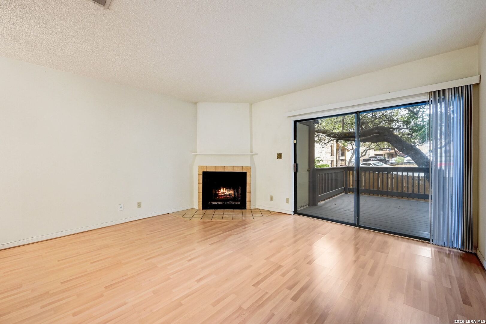 11815 Vance Jackson Road, Unit 1402 San Antonio, TX 78230 - Photo 9 of 29 a view of an empty room with wooden floor and a fireplace