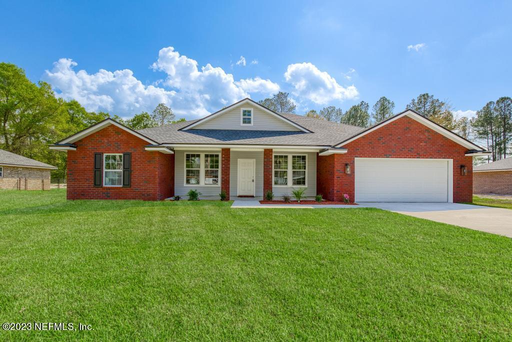 54150 Deerfield Country Club Road Callahan, FL 32011 - Photo 1 of 37 a view of a brick house with a big yard and large trees