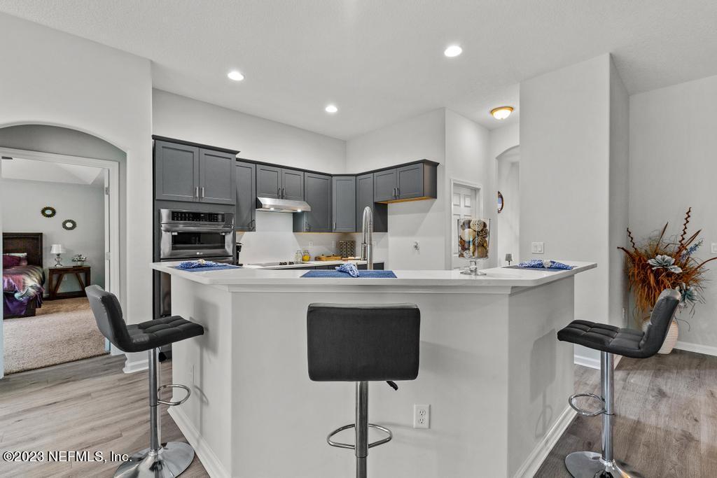 54150 Deerfield Country Club Road Callahan, FL 32011 - Photo 13 of 37 a kitchen with kitchen island cabinets and chairs in it