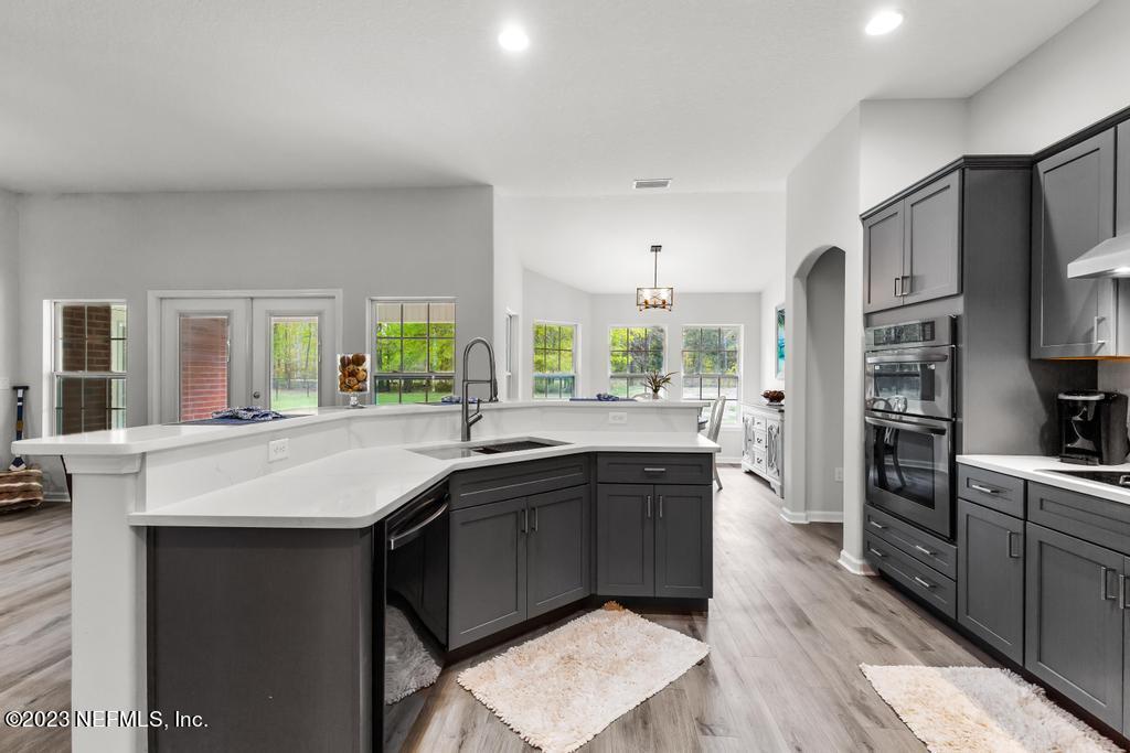 54150 Deerfield Country Club Road Callahan, FL 32011 - Photo 15 of 37 a kitchen with stainless steel appliances granite countertop a sink stove and refrigerator
