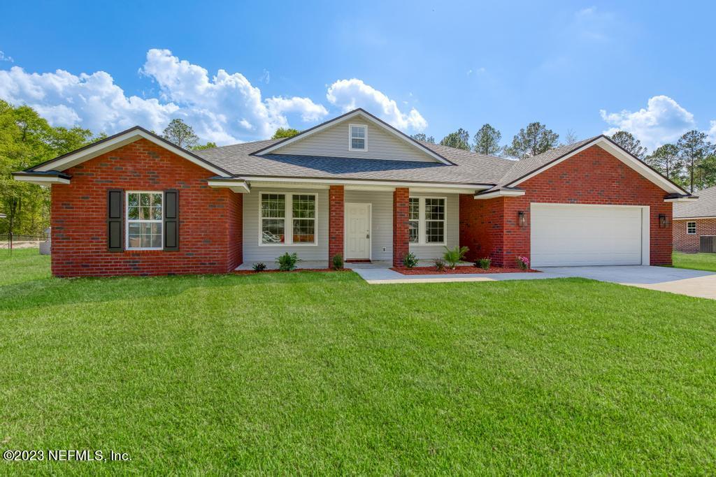 54150 Deerfield Country Club Road Callahan, FL 32011 - Photo 2 of 37 a front view of a house with a garden and yard