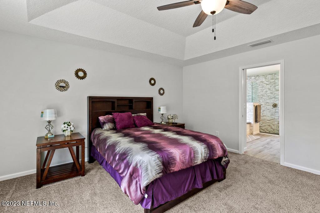 54150 Deerfield Country Club Road Callahan, FL 32011 - Photo 23 of 37 a bedroom with a bed and a chandelier