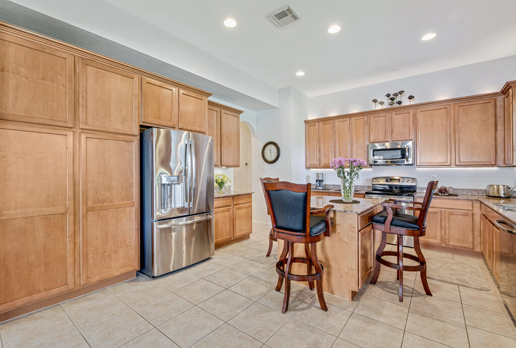 514 Cresta Circle West Palm Beach, FL 33413 - Photo 21 of 74 a kitchen with stainless steel appliances granite countertop a refrigerator and a stove top oven