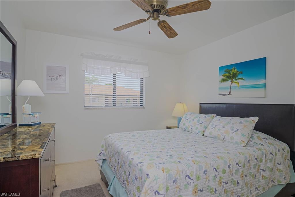 4790 South Cleveland Avenue, Unit 607 Fort Myers, FL 33907 - Photo 11 of 21 a bedroom with a bed and a chandelier