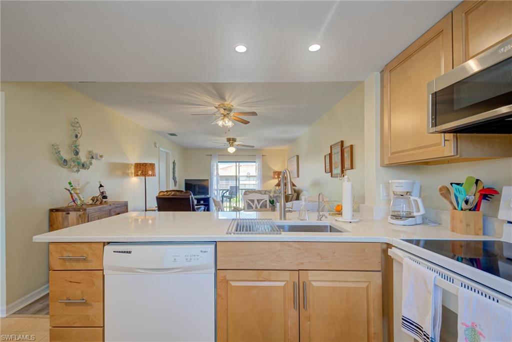 4790 South Cleveland Avenue, Unit 607 Fort Myers, FL 33907 - Photo 9 of 21 a kitchen with kitchen island a sink stainless steel appliances and cabinets