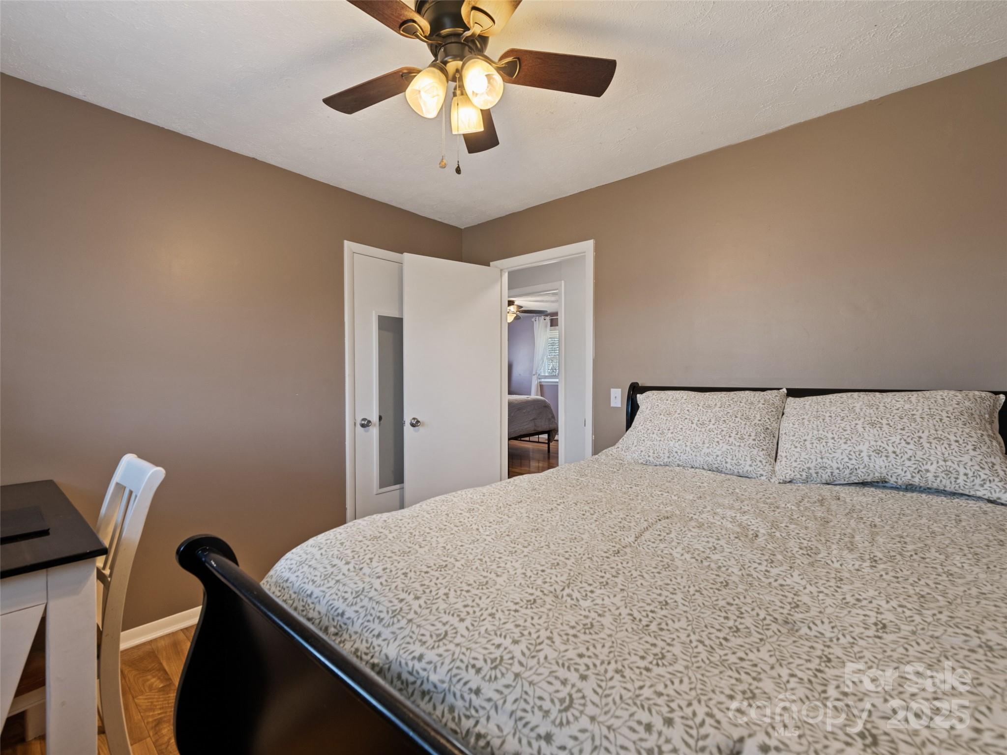 200 Stamey Cove Road Clyde, NC 28721 - Photo 32 of 36 a bedroom with a large bed and a chandelier