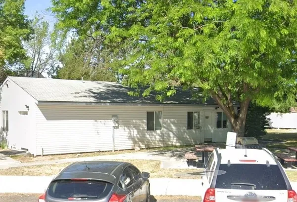 a view of a patio with a table and chairs under an umbrella