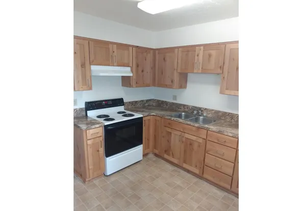 a kitchen with granite countertop a sink and a stove