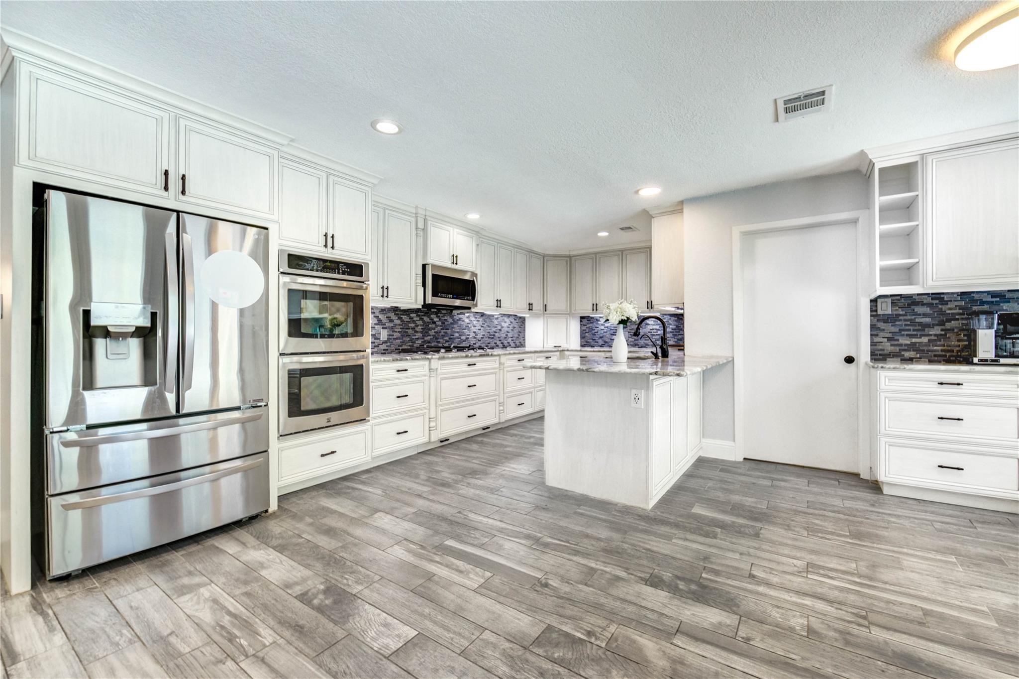1904 Nursery Road The Woodlands, TX 77380 - Photo 3 of 43 Enjoy family time in your bright and open kitchen complete with stainless steel appliances and coffee bar.