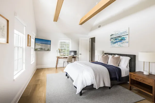 a spacious bedroom with a bed and a large window