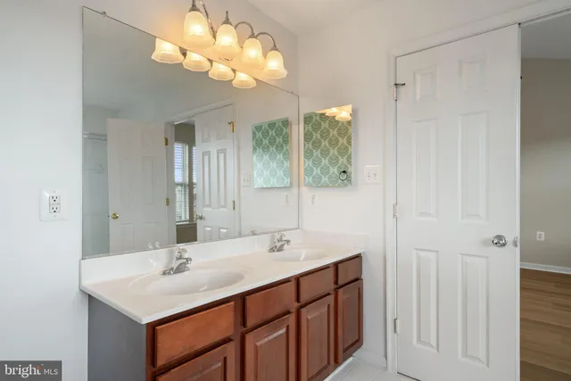a bathroom with a sink a light fixture and a mirror