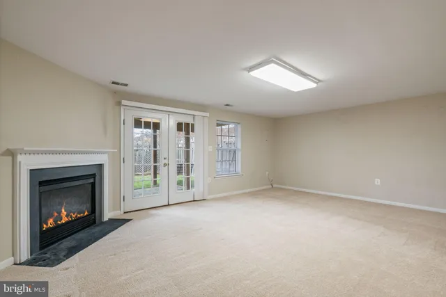 a view of an empty room with a fireplace and a window