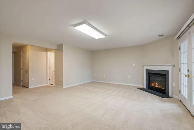 a view of an empty room with a fireplace and a window