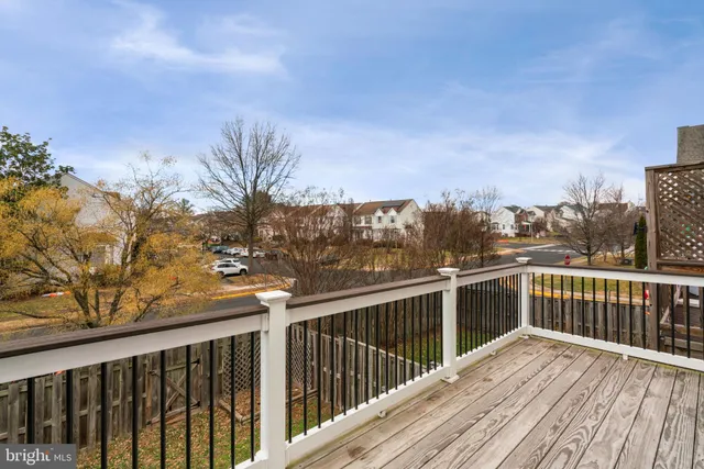 a view of a balcony with wooden floor and fence