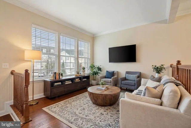 a living room with furniture a flat screen tv and a large window