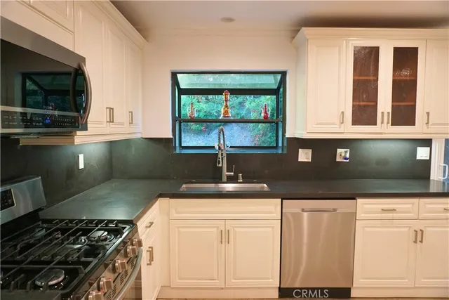 a kitchen with granite countertop a stove and a sink