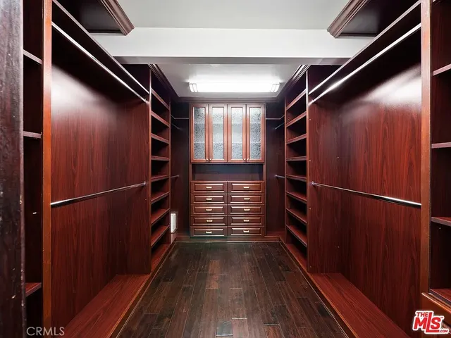 a view of walk in closet with wooden floor