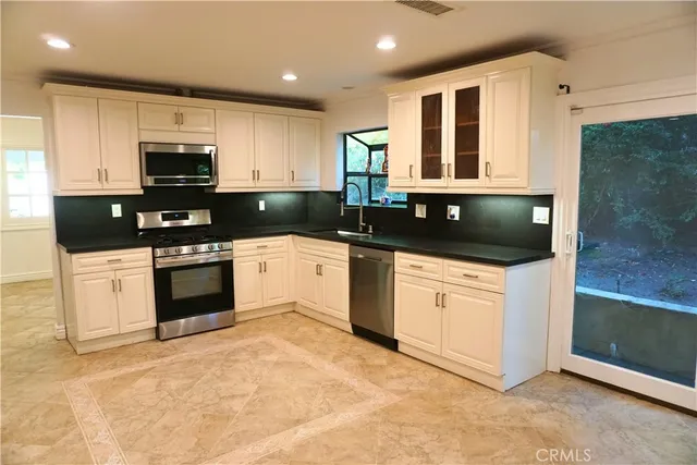 a kitchen with granite countertop white cabinets and white appliances