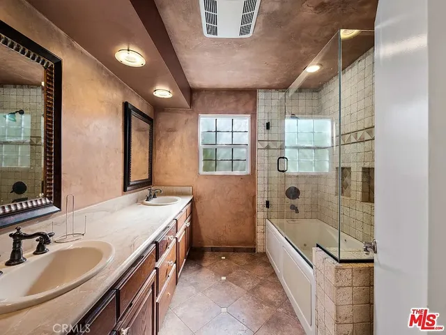a bathroom with a tub sink and mirror