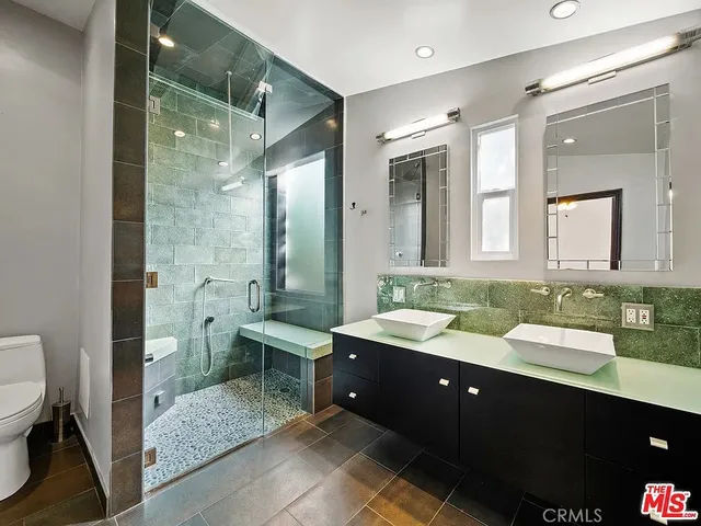 a spacious bathroom with a double vanity sink toilet and a mirror
