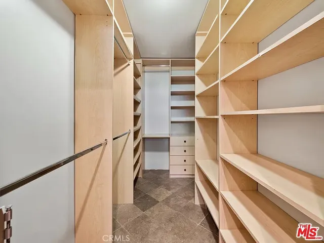 a view of walk in closet with empty racks