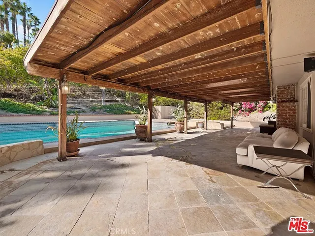 a view of a backyard with table and chairs under an umbrella
