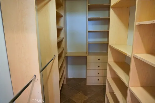 a view of walk in closet with empty racks