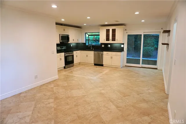 a kitchen with granite countertop a stove top oven a sink and cabinets
