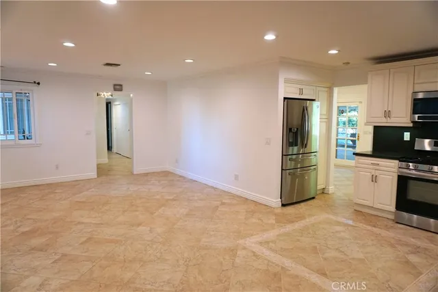 a view of kitchen with stainless steel appliances kitchen island refrigerator sink and stove