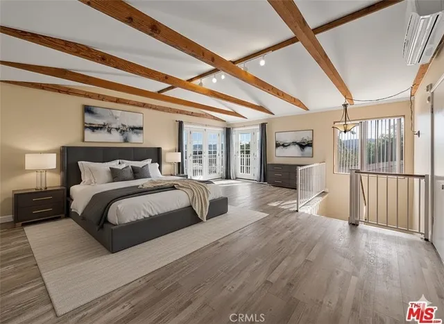 a spacious bedroom with a large bed and wooden floor